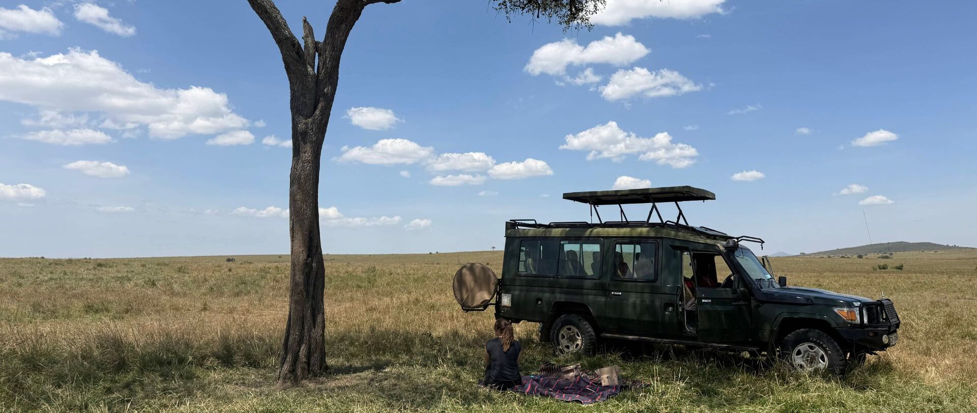 Petite pause près d'un arbre et du 4x4 du safari au Masai Mara en Afrique